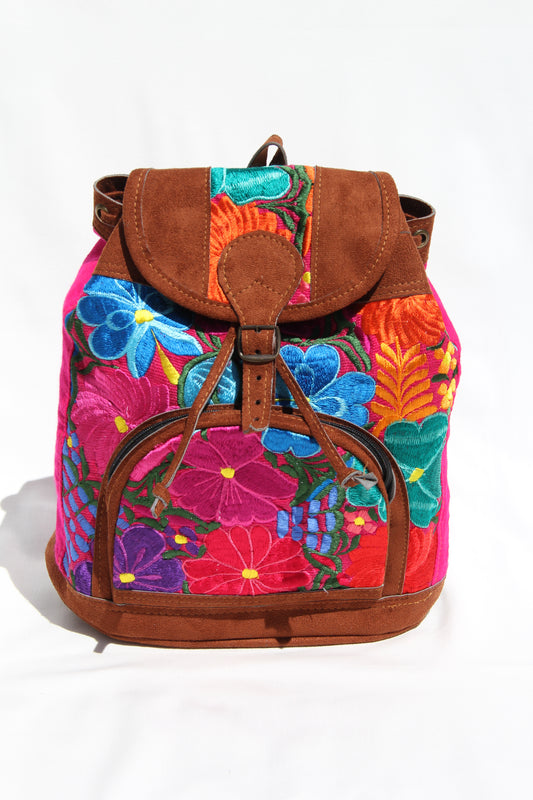 colorful huipil floral embroidery backpack with pink woven fabric and faux suede contrast with adjustable straps and front buckle closure with front zipper pocket the prefect travel, hiking or beach bag unique bag great for back to school take this bag on your next destination boho bag and hippie style bag a great standout accessories made in Guatemala