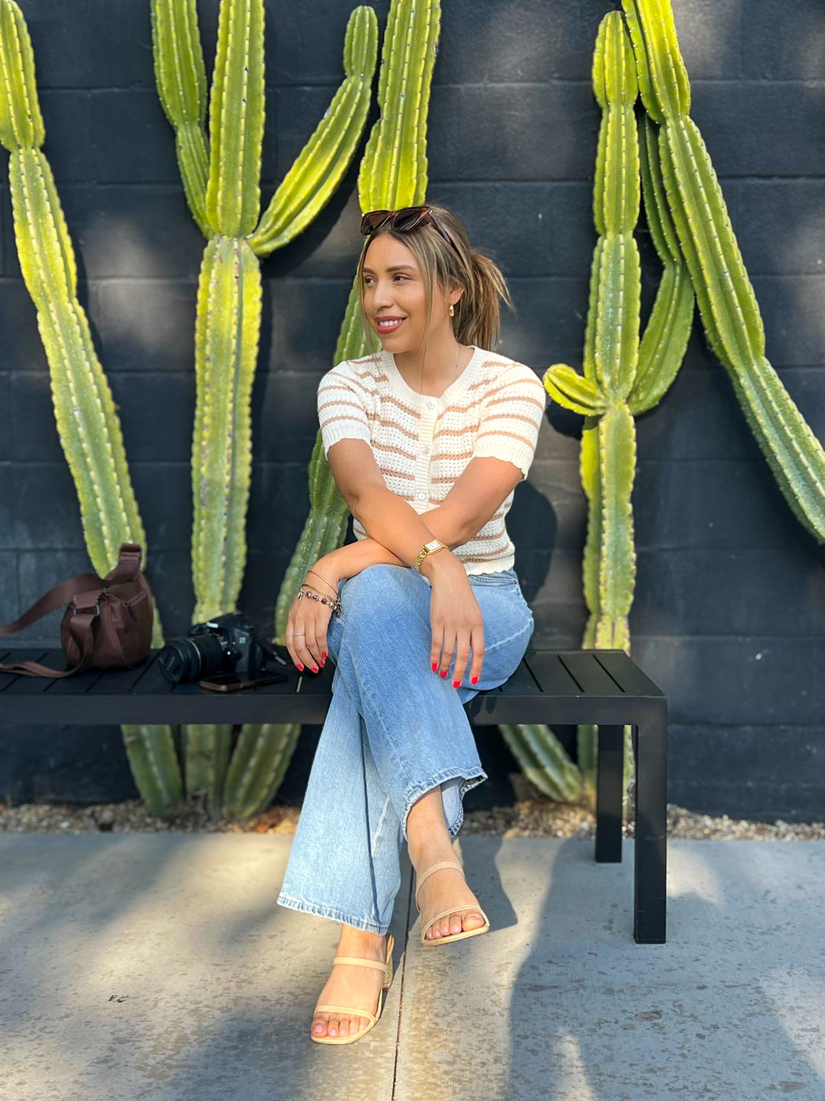 Woman sitting on a bench with cacti in the background