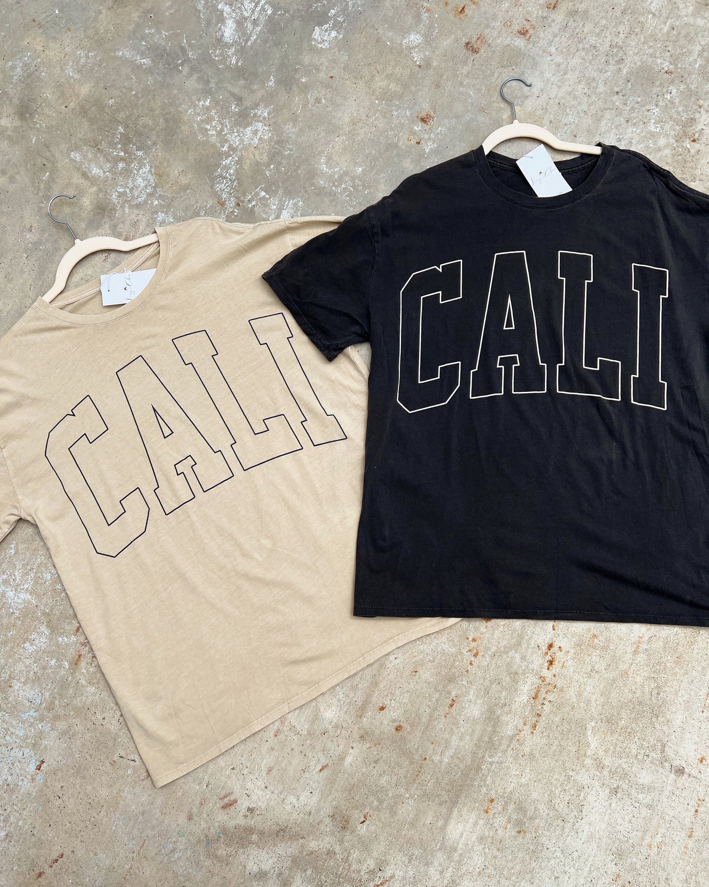 There's two oversized short sleeve t-shirts with CALI written on the front of shirt in large capital letters. There is a beige one and a charcoal one. They have a soft material and very lightweight. Can pair it with jeans or some comfortable biker shorts.