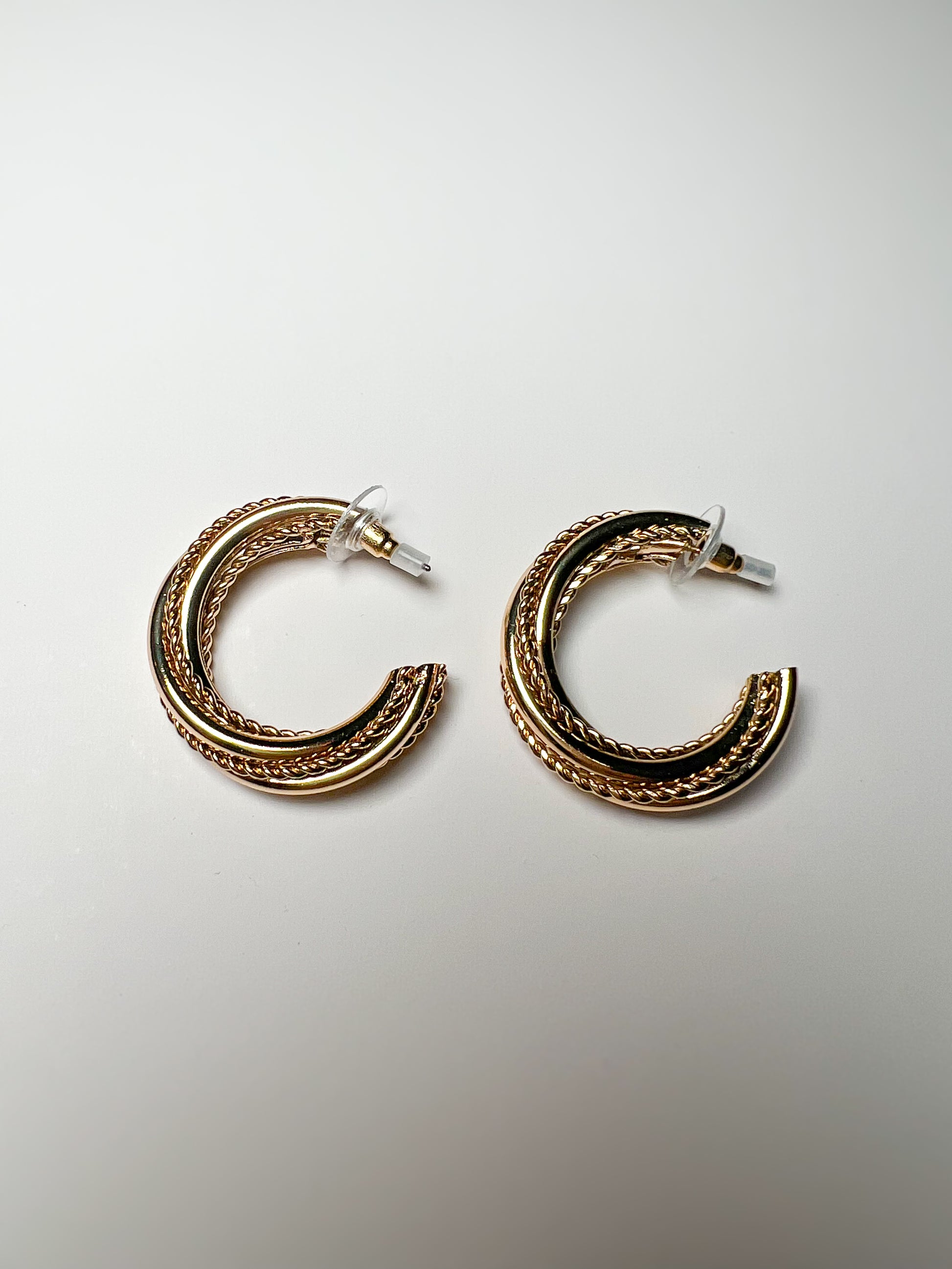 Pair of gold hoop earrings on a light gray background