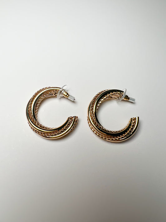 Pair of gold hoop earrings on a light gray background