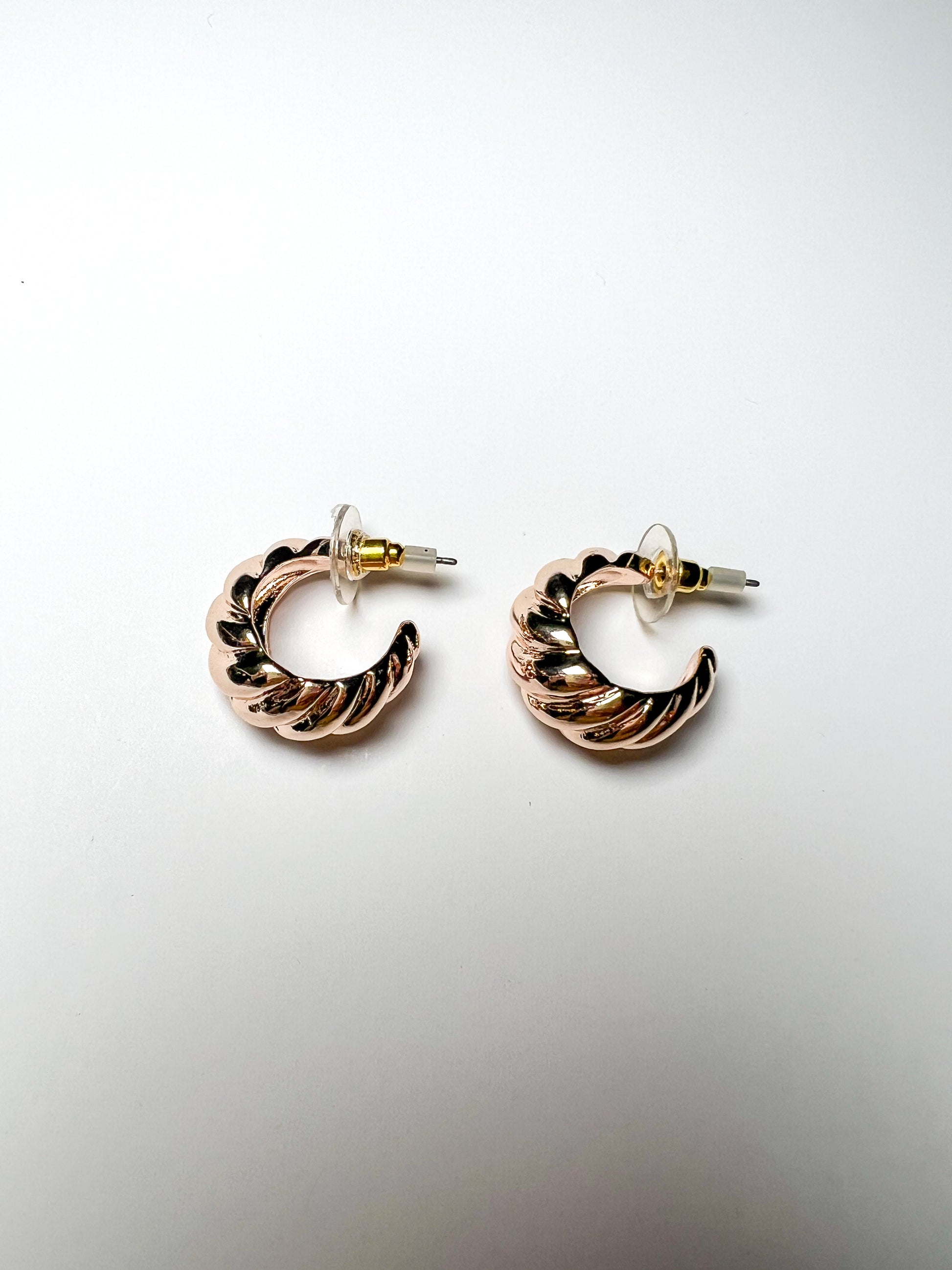 Pair of gold hoop earrings on a light gray background