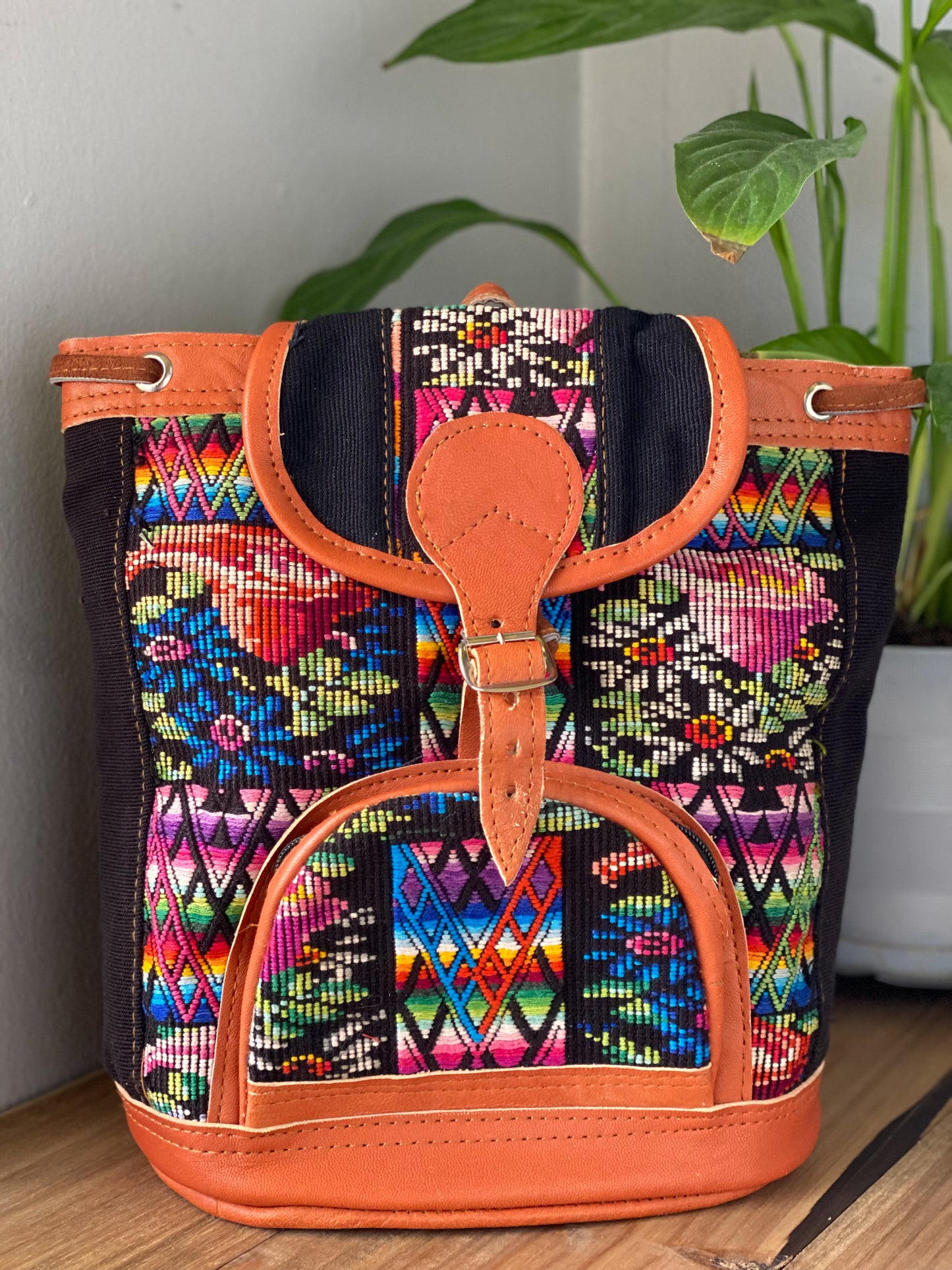 MIni leather huipil backpack hand woven with colorful embroidery and adjustable leather straps with front belt buckle closure and front zipper pocket perfect for hiking or beach trip handmade in Guatemala