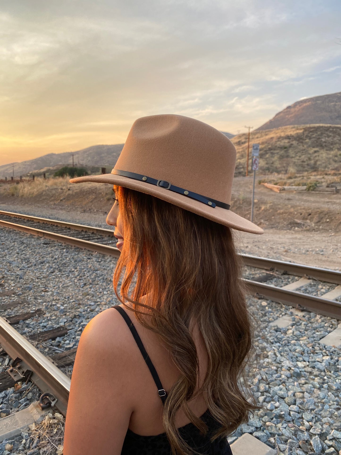 Women's Flat Wide Brim Felt Material Camel Brown Fedora Hat. Has A Side Black Belt Buckle Detail. Pinched Crown. Perfect for A Statement Piece. 