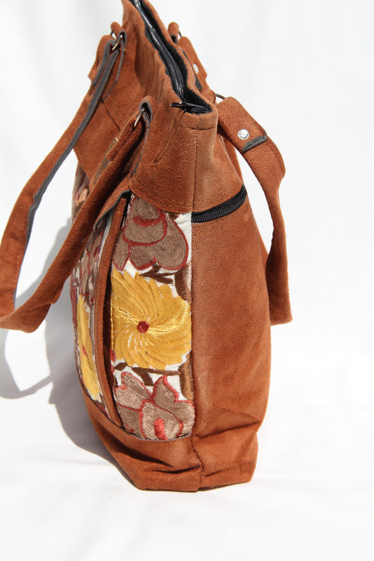 Huipil floral embroider handbag with faux suede shoulder straps and contrast details with a front pocket and top zipper zipper closure to prevent anything from falling out while using its beautiful yellow, brown and dark tones make this bag unique Perfect for shopping, taking to the beach or for your next vacation enough room to fit a laptop or any essentials for travel the perfect boho bag with two large back zipper pockets for extra compartments