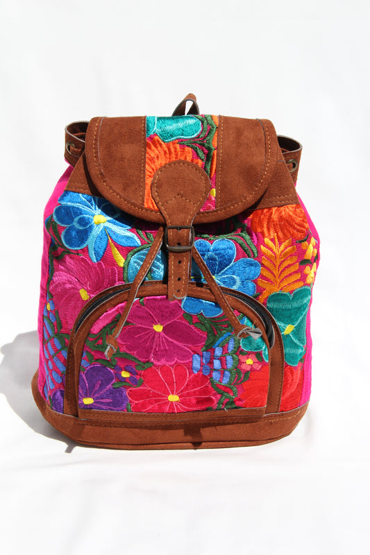colorful huipil floral embroidery backpack with pink woven fabric and faux suede contrast with adjustable straps and front buckle closure with front zipper pocket the prefect travel, hiking or beach bag unique bag great for back to school take this bag on your next destination boho bag and hippie style bag a great standout accessories made in Guatemala 