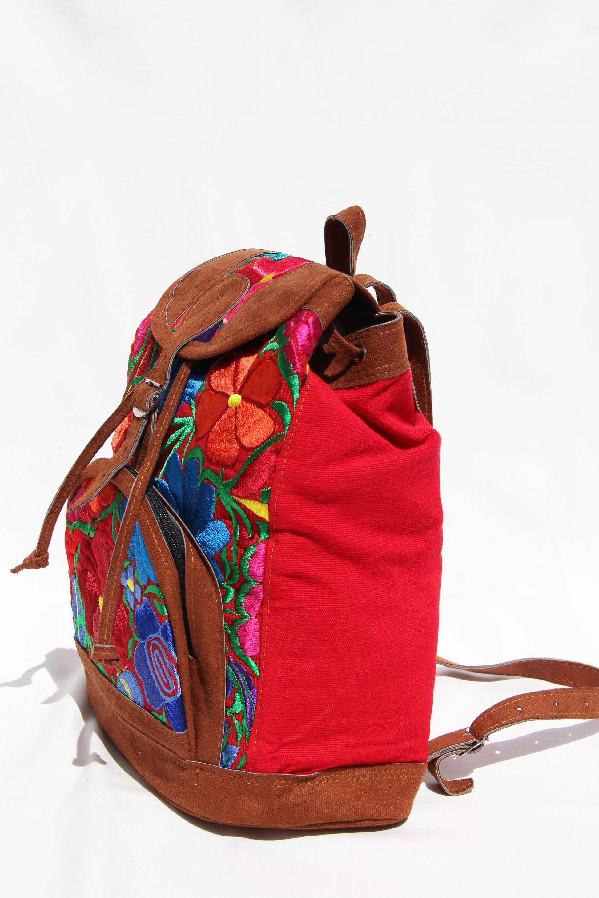 colorful huipil floral embroidery backpack with red woven fabric and faux suede contrast with adjustable straps and front buckle closure with front zipper pocket the prefect travel, hiking or beach bag unique bag great for back to school take this bag on your next destination boho bag and hippie style bag a great standout accessories made in Guatemala